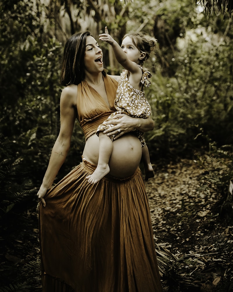 Maternity Photographer, a mother holds her young baby girl in the island forest