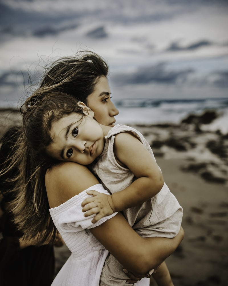 Family Photographer, Mother holds her daughter at the beach