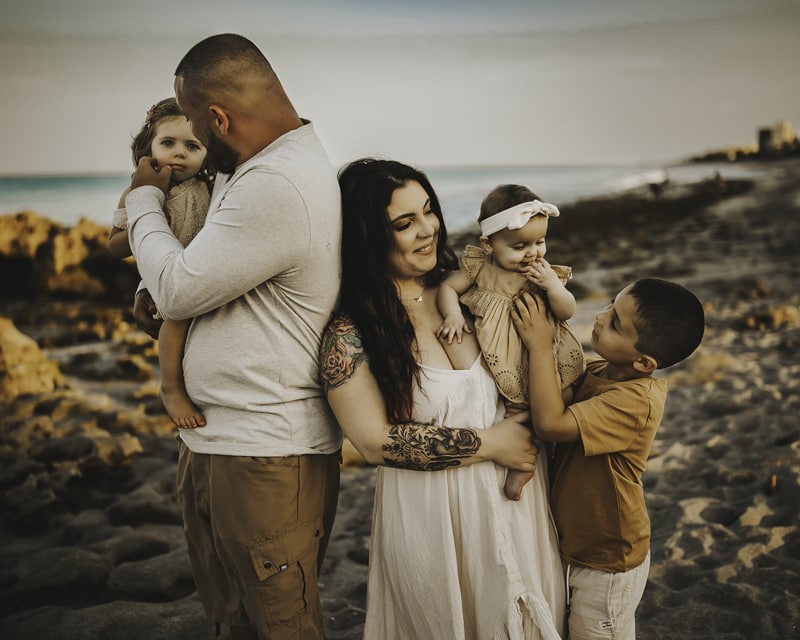 Family Photographer, Mom and dad are at the beach with their three young children