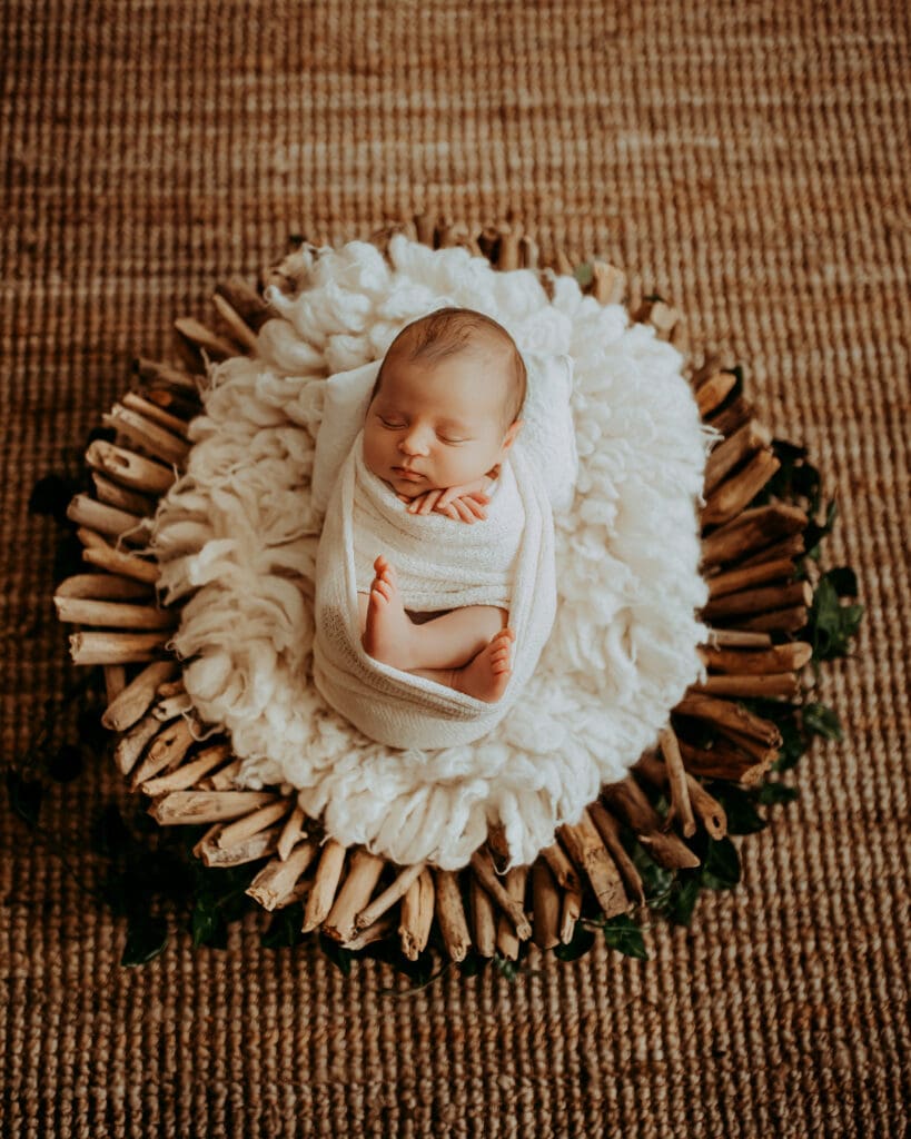 Family and Maternity Photographer, A baby sleeps cozily in a basket with blankets